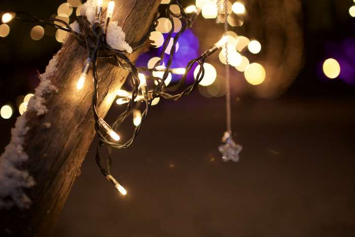 Christmas lights on a snowy wooden post