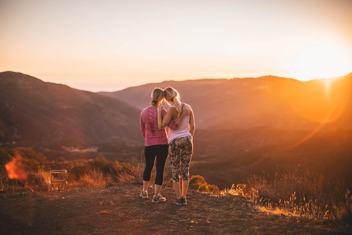 Two women watching a mountain sunset