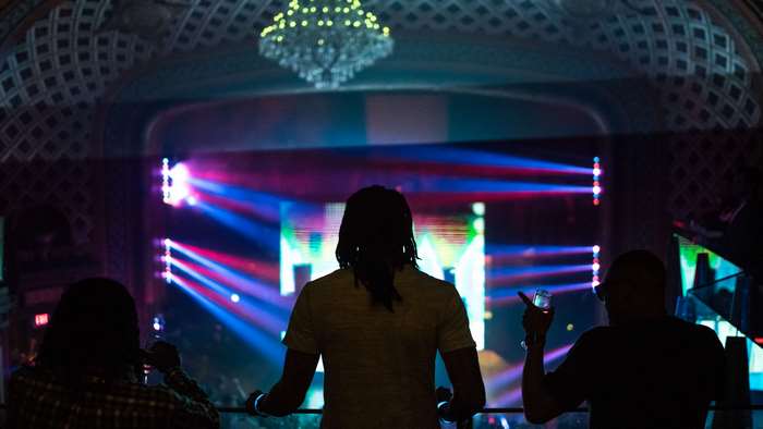 People in a club watching a stage with lights