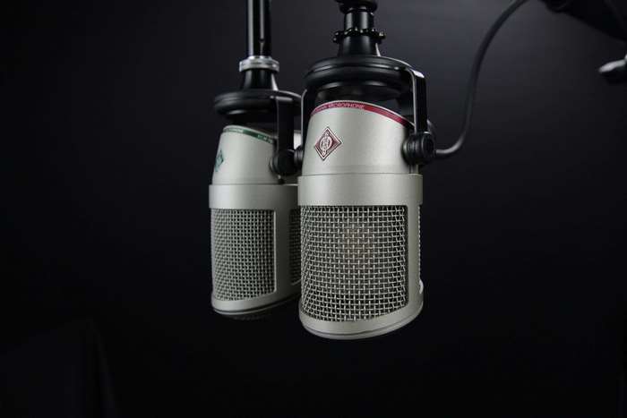 Two Neumann microphones on black background