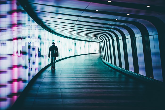 Man walking through a glowing tunnel at King's Cross Station