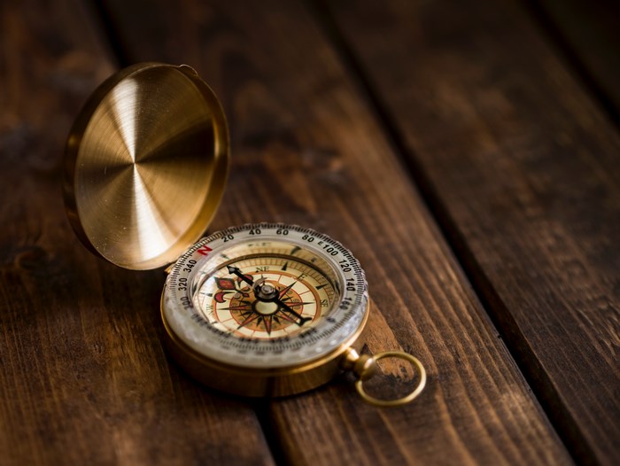 Vintage brass compass on a wooden table