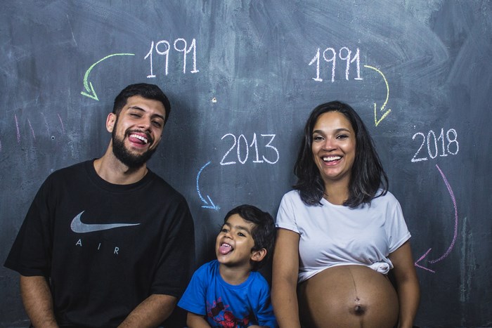 Family Poses in Front of Chalkboard with Years