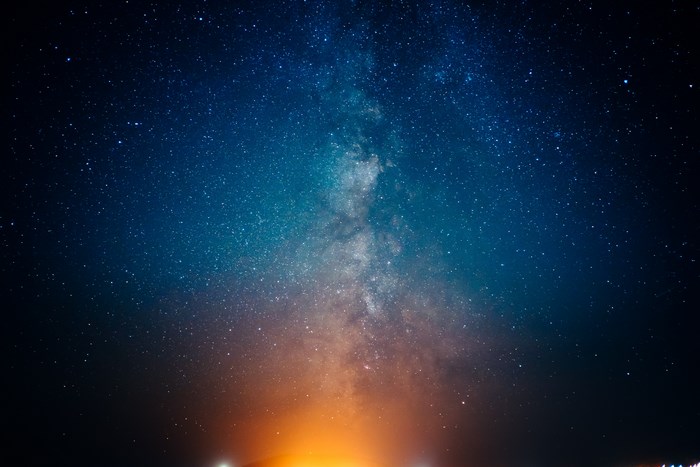 Milky Way galaxy with orange glow from below