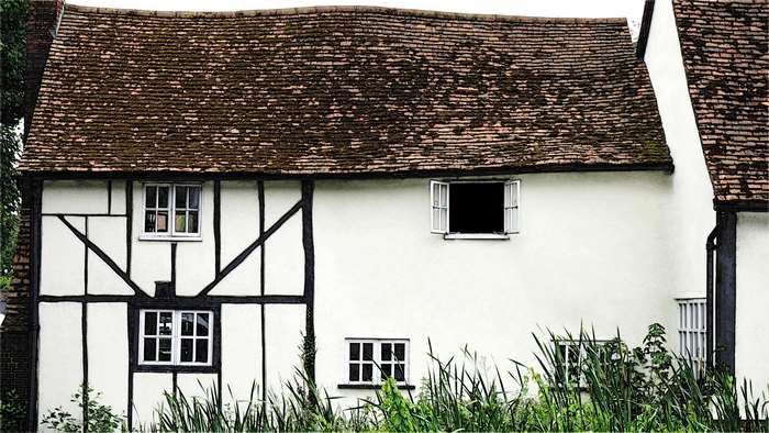 Tudor style house with tiled roof and white walls
