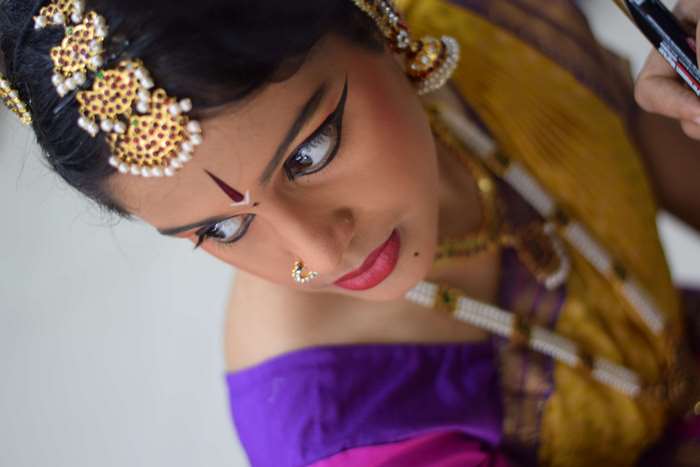 Bharatnatyam dancer with traditional Indian attire and makeup
