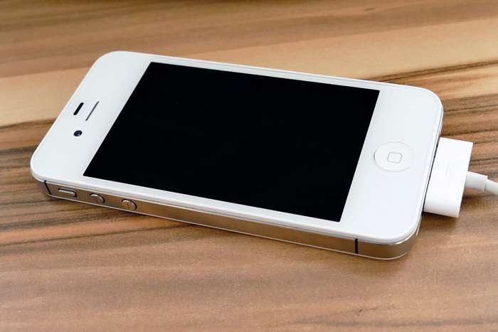 White iPhone 4s Charging on Wooden Surface 4K