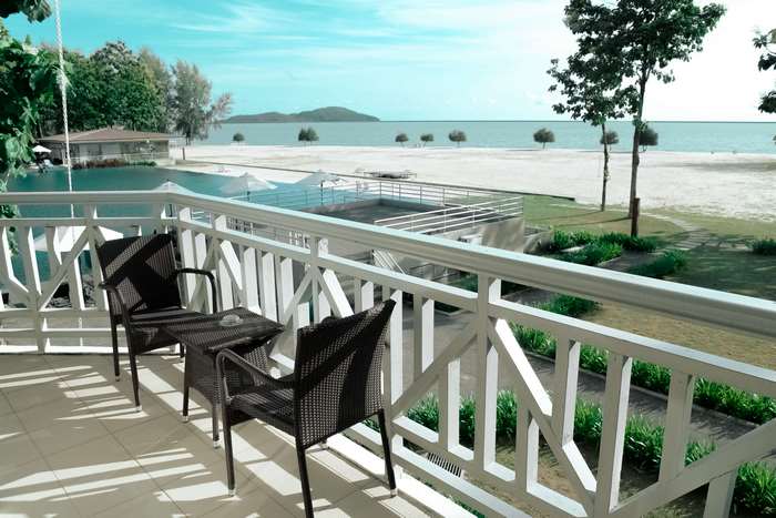 Balcony with chairs overlooking a beach and ocean