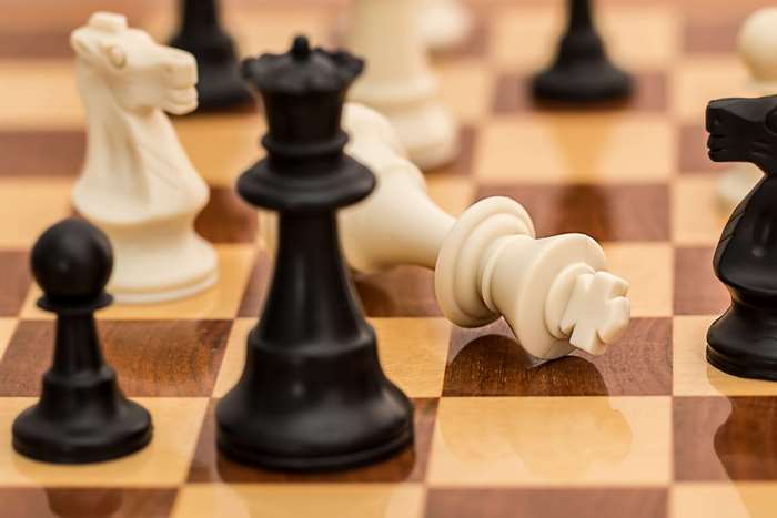Chessboard with fallen white king and black queen