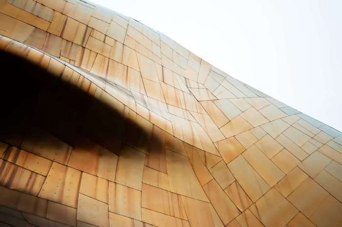 Abstract architectural detail with bronze panels and shadow
