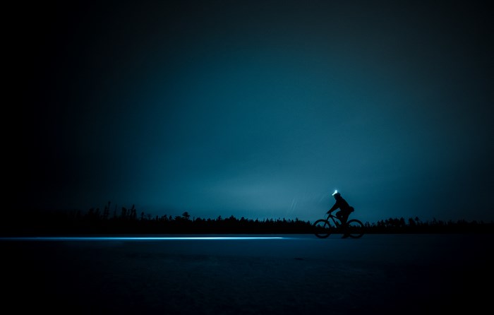 Silhouette of Cyclist Riding Fatbike on Snowy Terrain