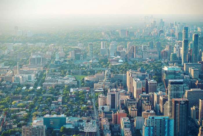 Aerial view of a sprawling city with numerous skyscrapers and green spaces