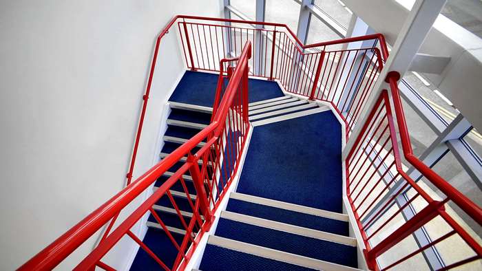 Modern Staircase with Red Handrails and Blue Carpet