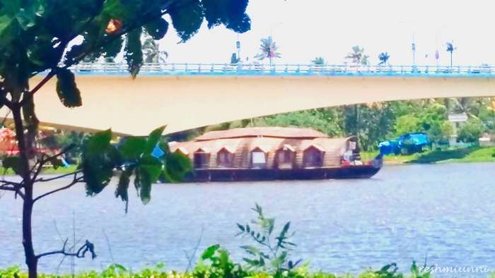 Houseboat on water under a bridge in Kerala