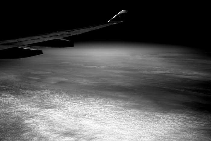 Airplane wing over clouds at night