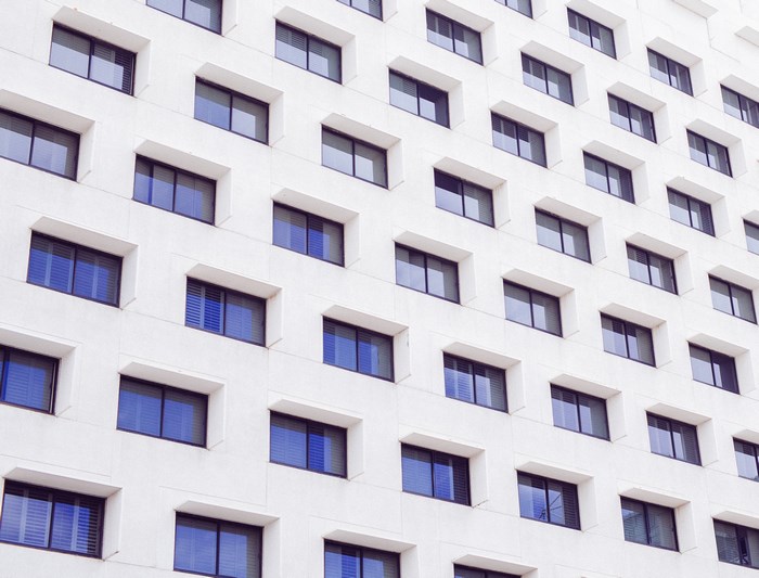 Minimalist facade of a white building with blue windows