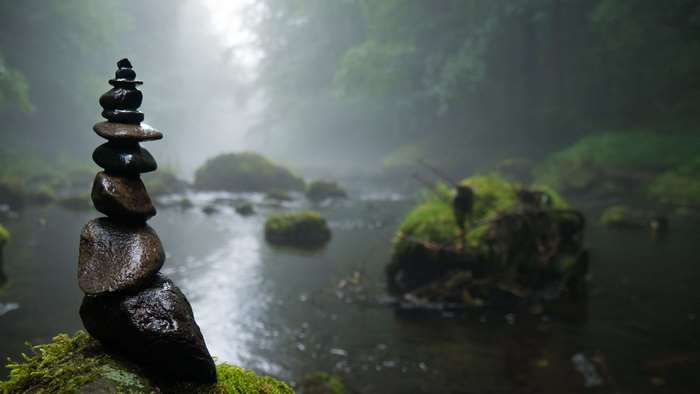 Stack of wet stones in a foggy forest by a river