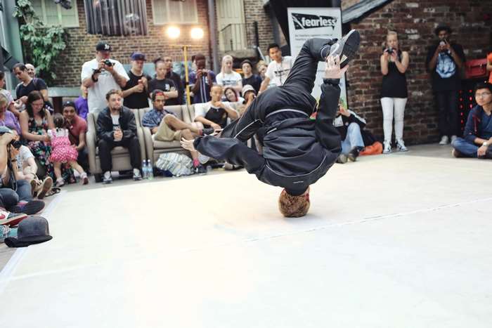 Breakdancer performs a headstand in front of a crowd