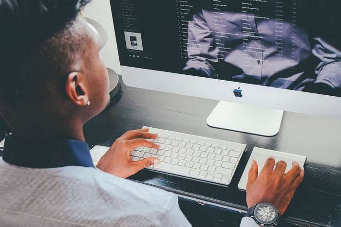 Man using Apple iMac computer and keyboard