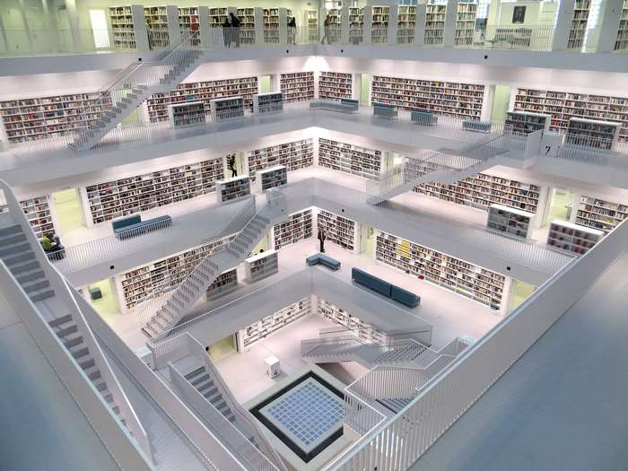 Modern library interior with white bookshelves and stairs