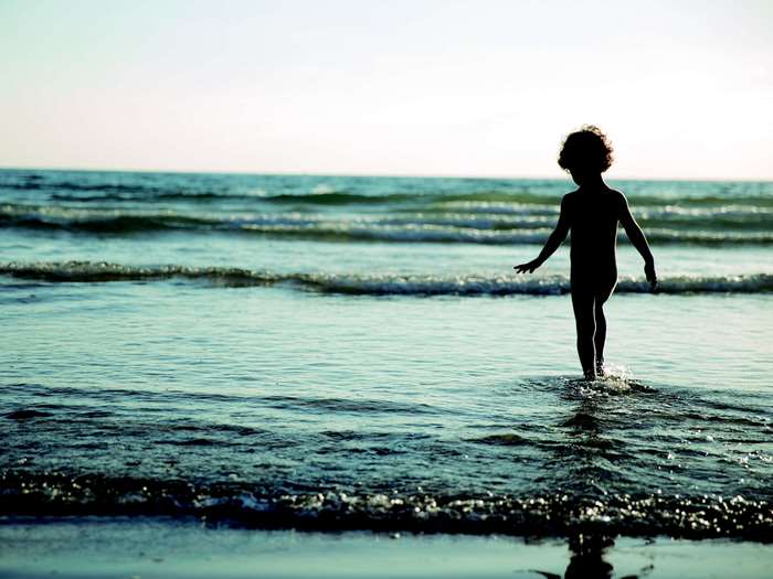Child walking in the ocean waves