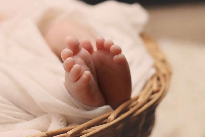 Newborn baby feet in a wicker basket