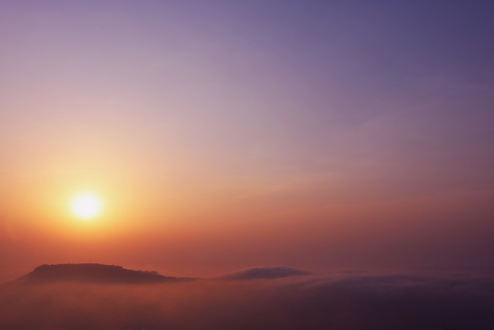 Sunrise over mountains above the clouds
