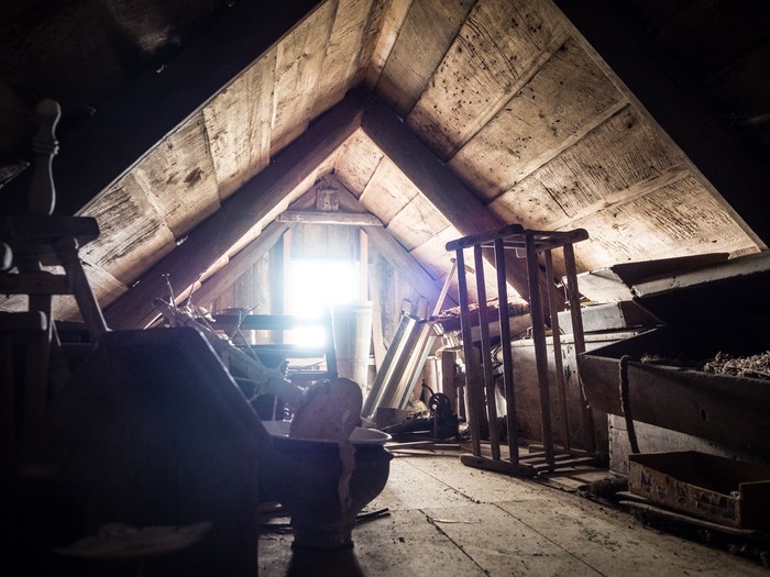 Abandoned attic with wooden beams and window light