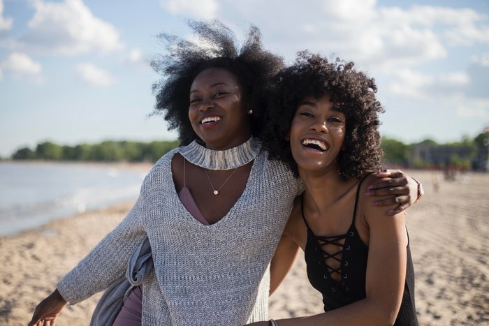 Two smiling African American women on a beach