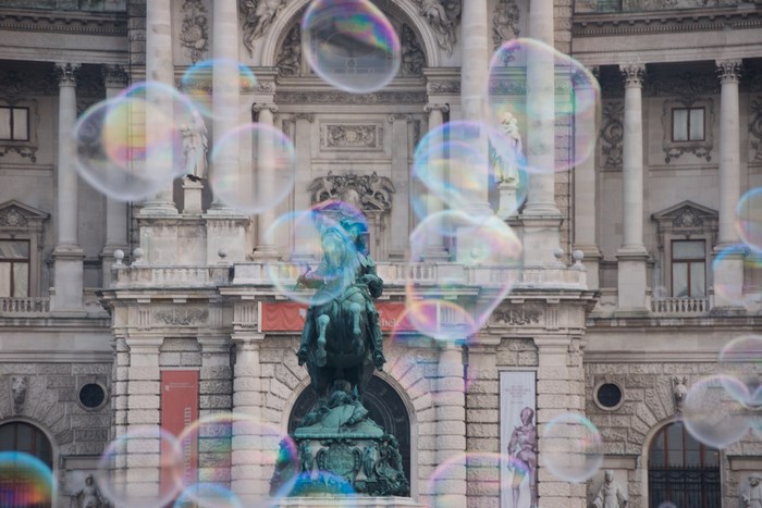 Bubbles in front of a grand building with a statue