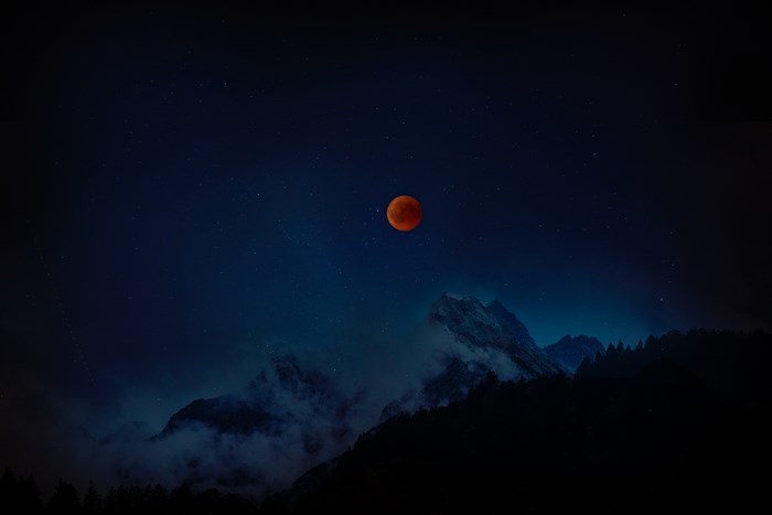 Blood Moon Supermoon Eclipse Over Mountain Silhouettes
