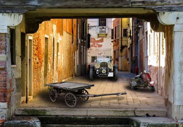 Vintage car, moped, and cart in an old Italian alley