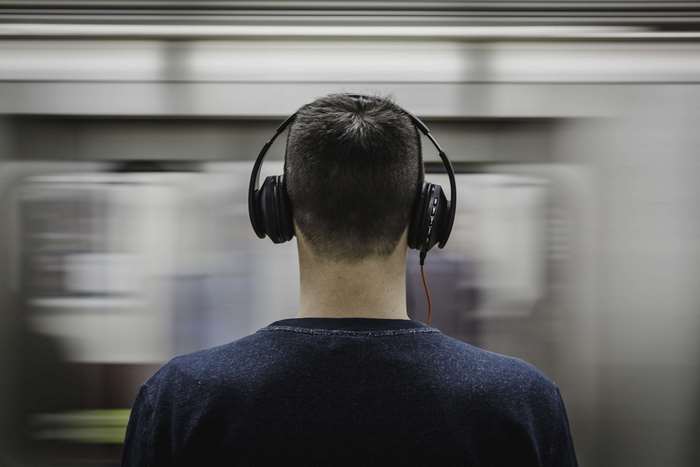 Man wearing headphones on a train 4K