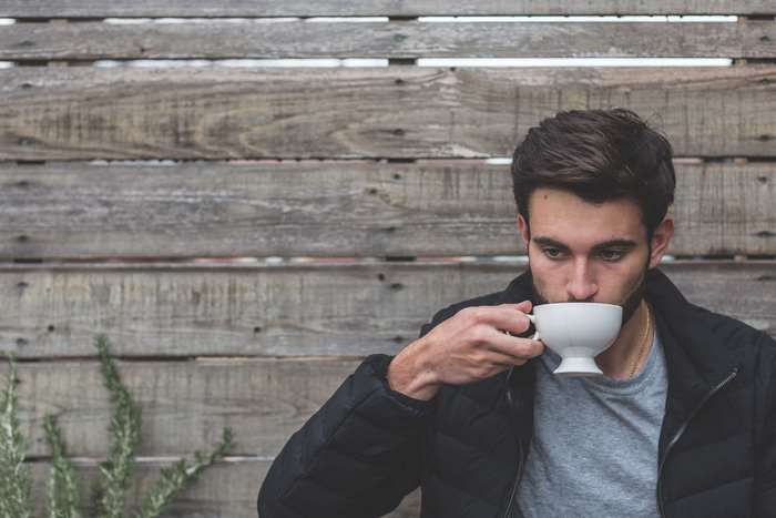 Man drinking coffee outdoors