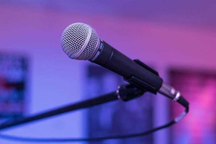Shure SM58 microphone on a stand with purple lighting