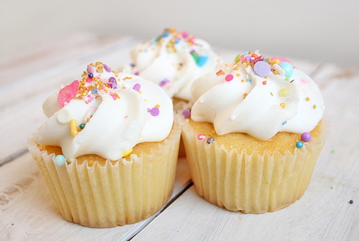 Three Vanilla Cupcakes with White Frosting and Sprinkles