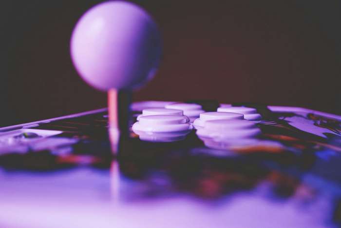Close up of a purple arcade joystick and buttons