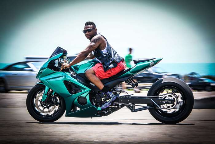 Man riding a green Kawasaki motorcycle