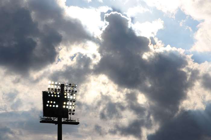 Stadium floodlights against a cloudy sky