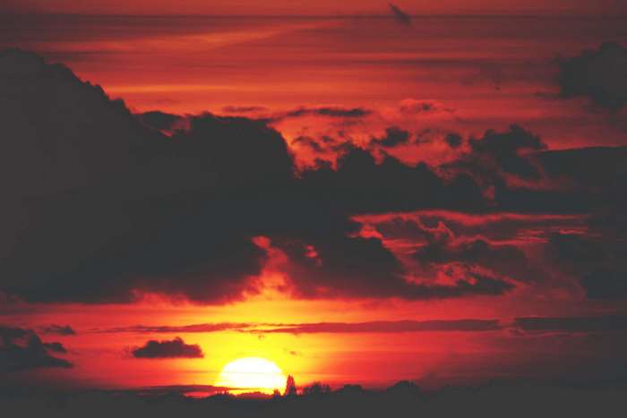 Sunset with dark clouds and bright sun