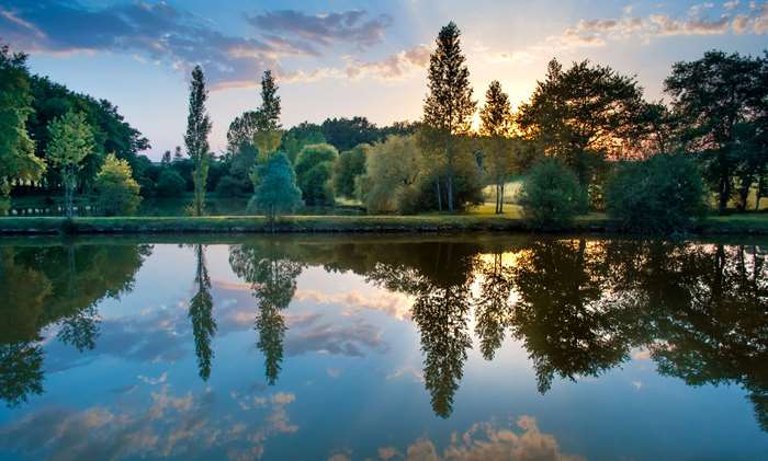 Sunset over a tranquil lake with reflections