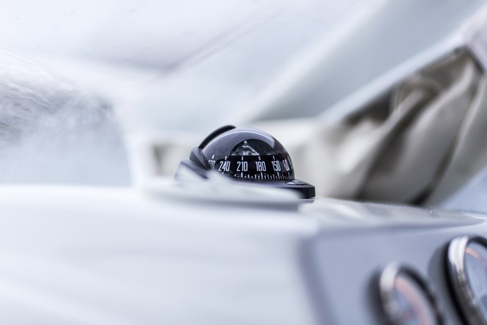 Close-up of a boat compass on a white dashboard