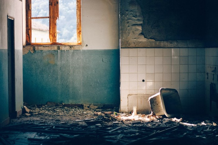Abandoned hospital interior with broken window and bathtub