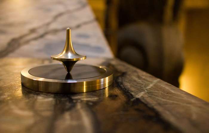 Brass spinning top on a marble surface