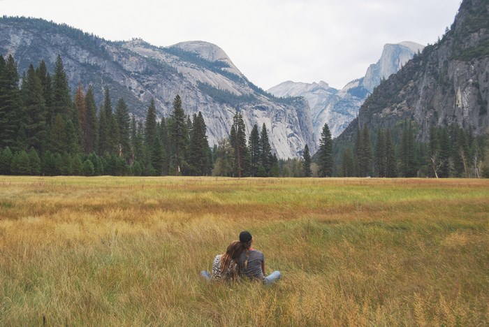 Couple sitting in a field in Yosemite National Park