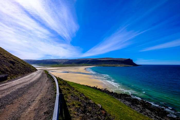 Scenic coastal road overlooking a sandy beach and ocean