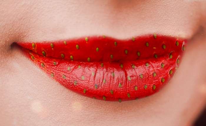 Close-up of lips painted like a strawberry
