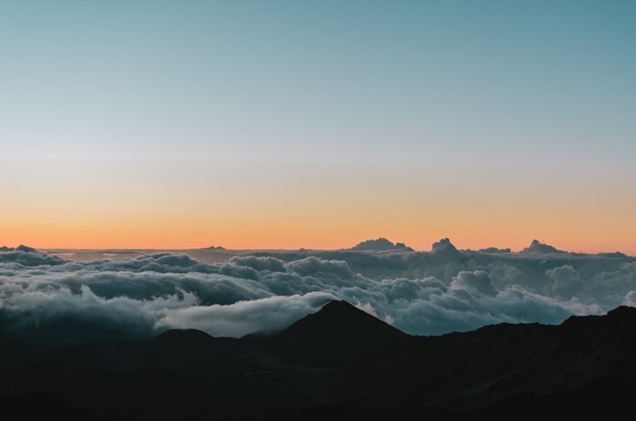 Sunrise over clouds above Maui mountains