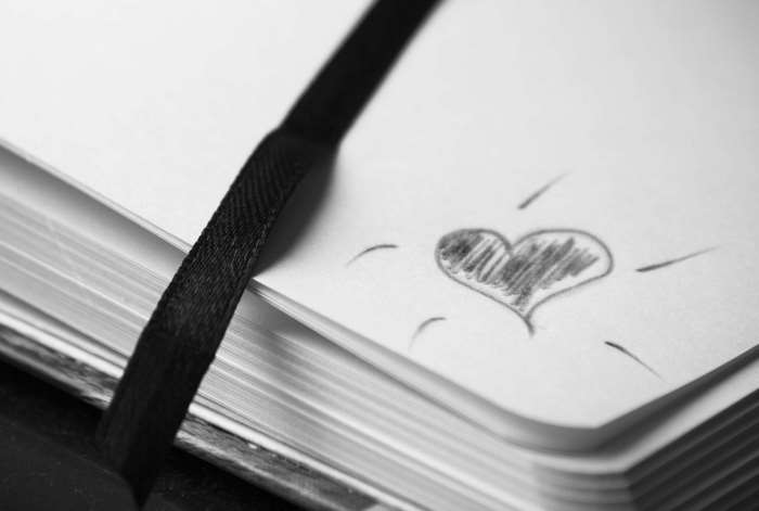 Notebook with a heart drawing and black ribbon