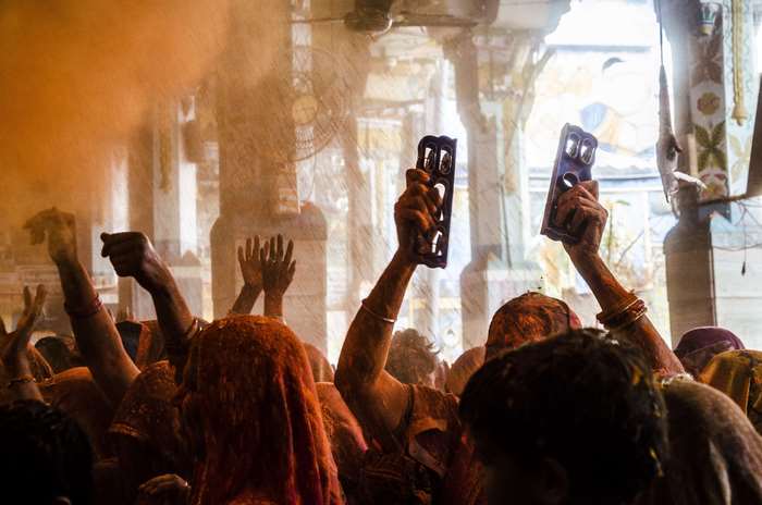 People celebrating Holi with colored powder and instruments